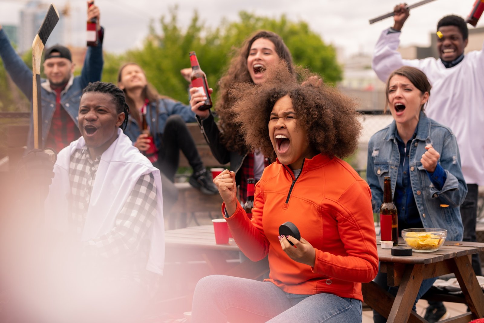 Young ecstatic hockey fans watching broadcast of world championship outdoors